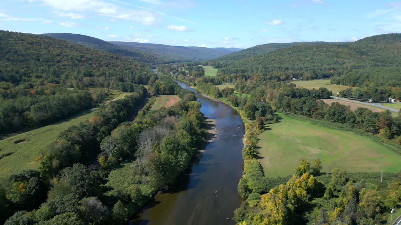 Drone ascends and orbits to establish beautiful view of Mohawk Trail by Deerfield River in Western Massachusetts New England USA