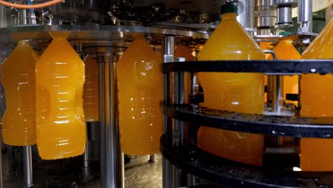 bottling of natural orange juice on automatic conveyor line on shop in factory.