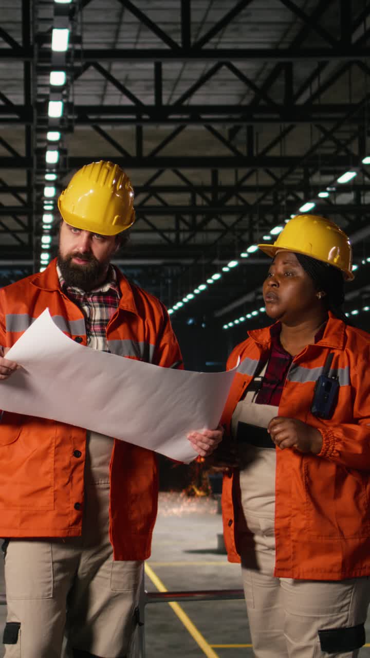 Vertical Video Diverse engineers reviewing manufacturing blueprints and technical drawings