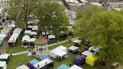 AERIAL---Dogwood-Festival-booths,-Siloam-Springs,-AR,-rising-shot-tilt-down