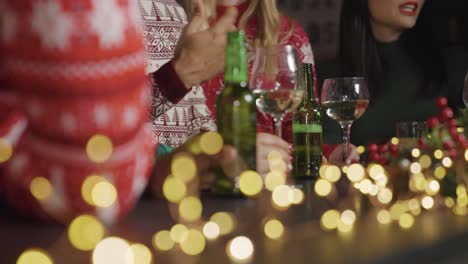 Kamerafahrt-Von-Freunden,-Die-Während-Der-Weihnachtsfeier-An-Der-Bar-Mit-Getränken-Sitzen