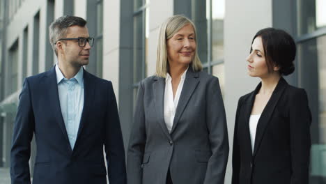 portrait of businessman and female colleagues in the street and smiling joyfully to camera