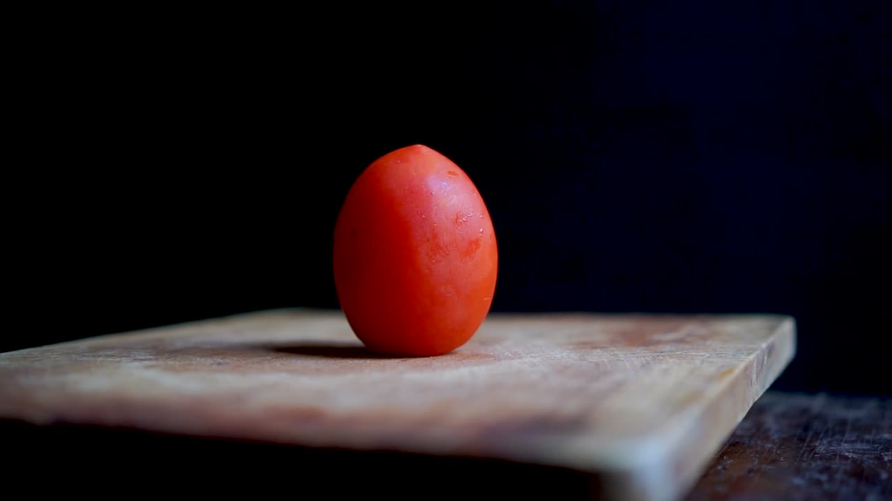 Cutting a Tomato on a Wooden Board