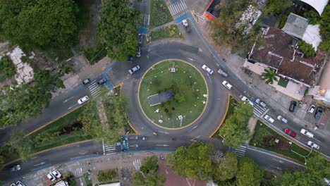 hiperlapso ascendente aéreo del tráfico en la rotonda en ciudad jardín