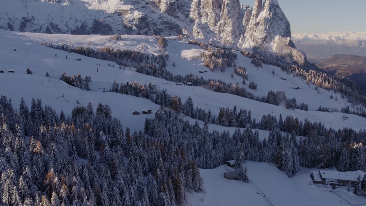 Montagne innevate e villaggio all'Alpe di Siusi, Alto Adige, Italia