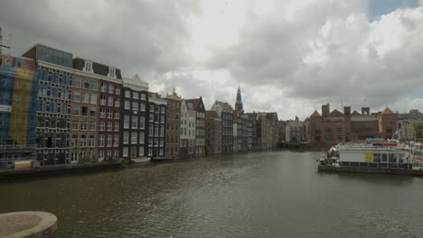 panning over canal in amsterdam with houses and docks on water