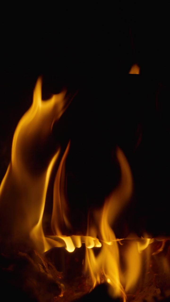 Fiamme di un braciere che bruciano lentamente attorno alla legna da ardere.
