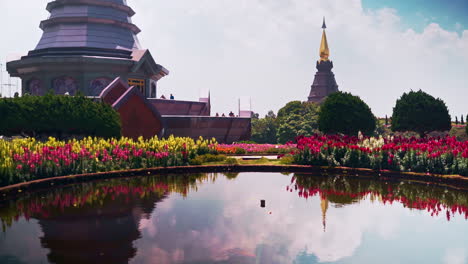 Pond-below-Twin-Pagodas-of-Two-Chedis-in-garden-with-blooming-flowers