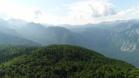 Aerial-Drone-Above-Vogel-Mountain-Slovenian-Julian-Alps,-Green-Hills-Skyline-and-Heaven-Clouds-Blue-and-White-Horizon-in-Triglav-National-Park