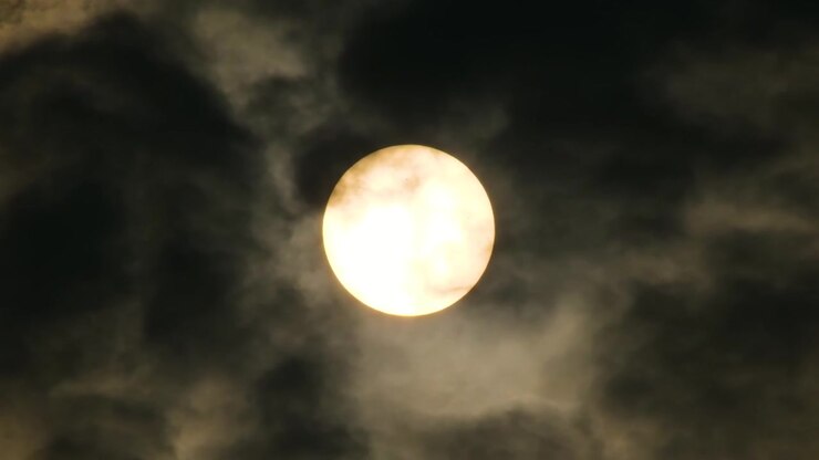 Close up, Fast moving black clouds across bright full moon.