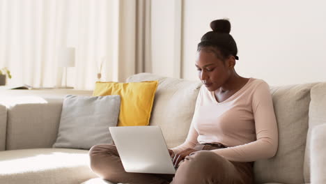 mujer trabajando desde casa en una computadora portátil