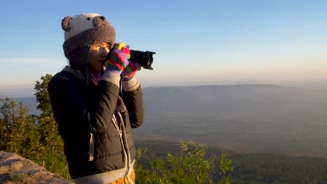 Frau,-Die-Morgens-Ein-Foto-Auf-Der-Klippe-Macht,-Mit-Einem-Wunderschönen-Himmel-Und-Bergen