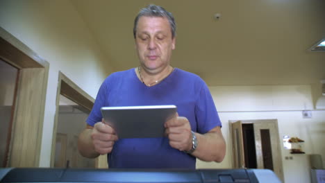 Man-with-touch-pad-exercising-on-treadmill