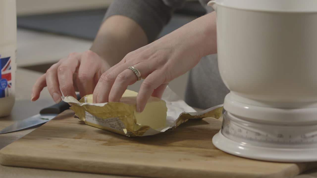 mano femenina abriendo un paquete de mantequilla