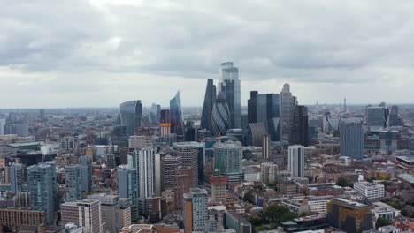 Dia--Und-Schwenkaufnahme-Des-Geschäftszentrums.-Ikonische-Moderne-Wolkenkratzer-Im-Stadtviertel-Von-Osten.-Bedeckter-Himmel.-London,-Vereinigtes-Königreich