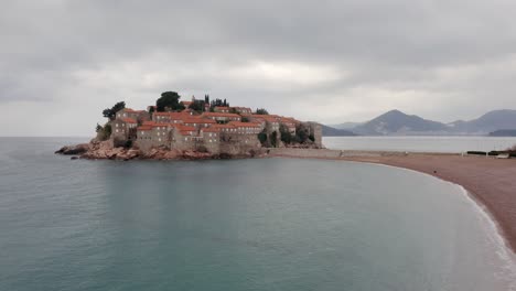 AERIAL---Sveti-Stefan-island-and-Villa-Milocer-in-Montenegro,-forward-shot