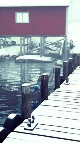 snow covered dock and red house