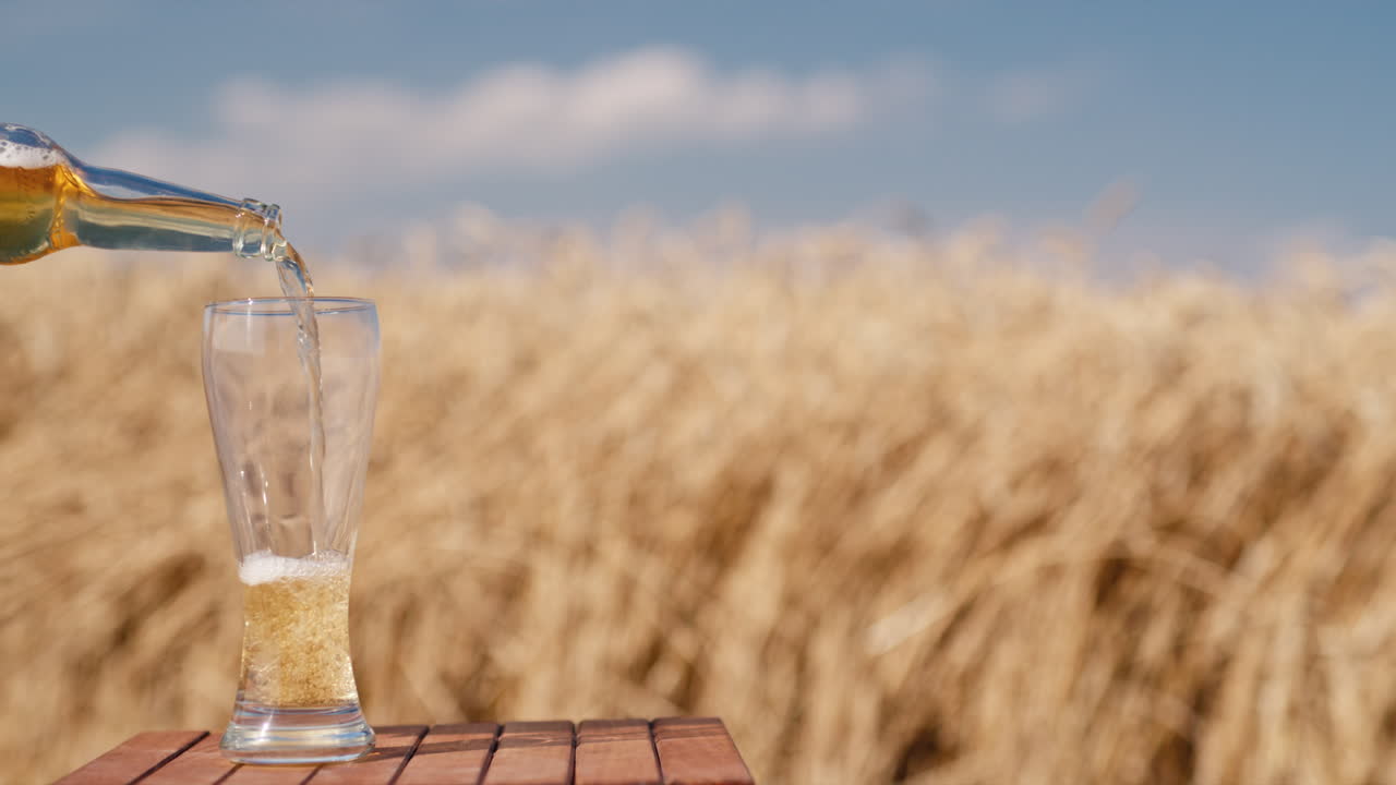 el hombre vierte cerveza de una botella en un vaso 2