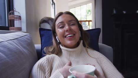 portrait of woman waving while drinking coffee