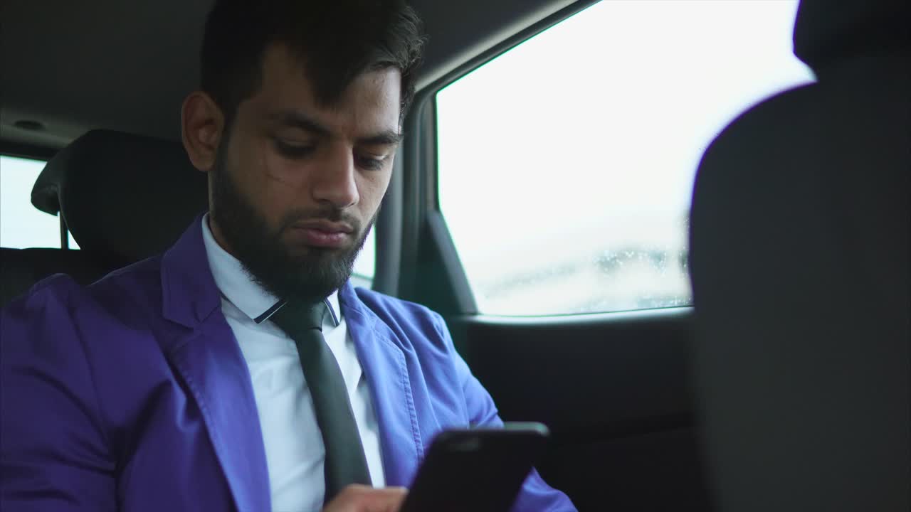Businessman using mobile phone in a car