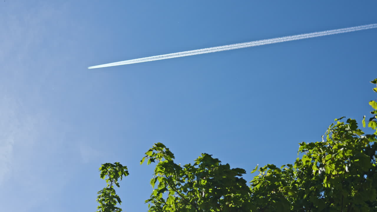 Cielo blu senza nuvole con un aereo che vola e lascia una scia. Un aereo solitario nel cielo. Un aereo che vola contro il cielo.