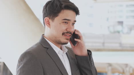느린 동작 장면 성인 중동 사업가 스마트폰을 사용하여 파트너 또는 동료와 전화하고 대화하여 라이프 스타일 비즈니스 개념에 대한 조언과 상담을하십시오.