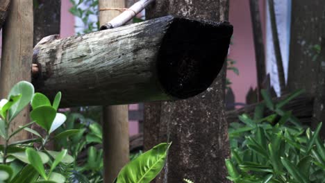 agua monjolo con agua fluyendo generando energía pisando madera