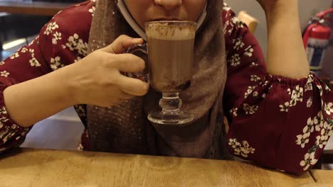 woman enjoying hot chocolate in a cafe