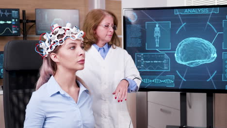 female doctor in brain science lookin at tv screen