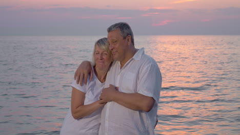 una pareja madura sonriente mirando a la cámara.