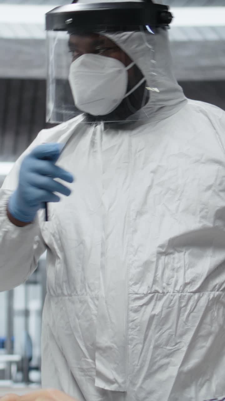 Vertical Video Scientific team in a virology unit monitors patient for symptoms of infection