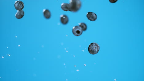 Explosion-of-flying-blueberries-and-water,-focus-middle-of-group