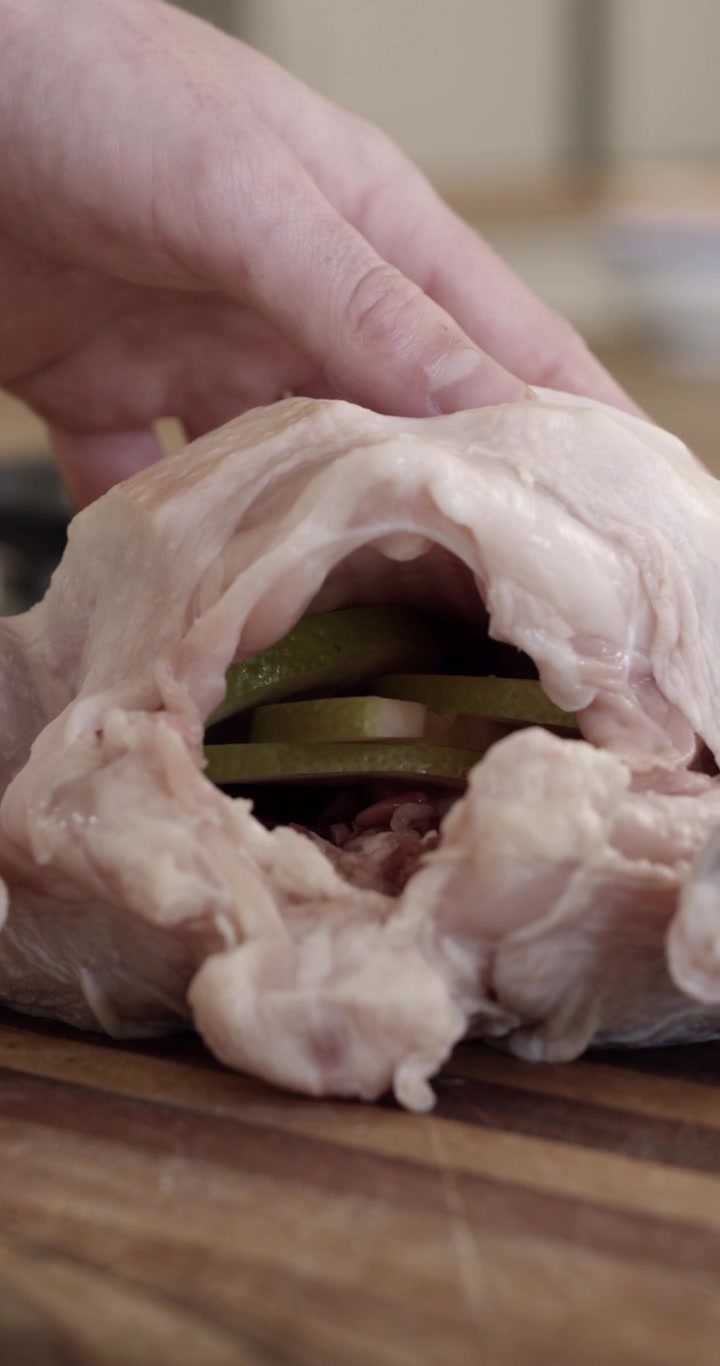 Chef Stuffing Raw Whole Chicken with Lime and Rosemary