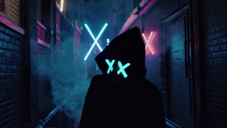 person in a neon mask in a dark alley at night