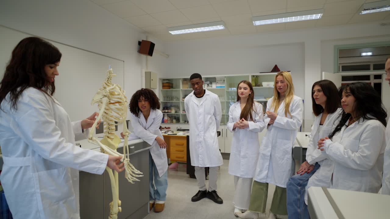 Medical students learning anatomy with a skeleton in a classroom