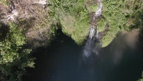 Luftaufnahme-Einer-Versteckten-Wasserfalllagune,-Umgeben-Von-Laub