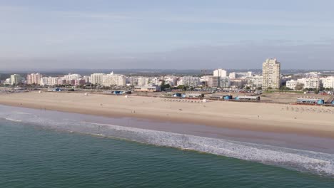 Aerial-Establishing-shot-of-Montegordo-beach-with-touristic-waterfront-buildings,-Orbit-shot