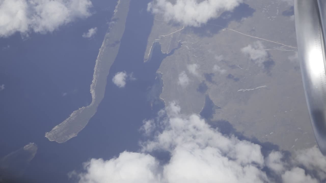 Aerial view revealing scenic coastline, soaring above clouds and croatian islands with expansive blue sky and peaceful horizon