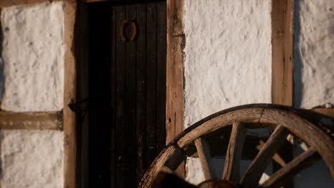 old wood wheel and black door at white house