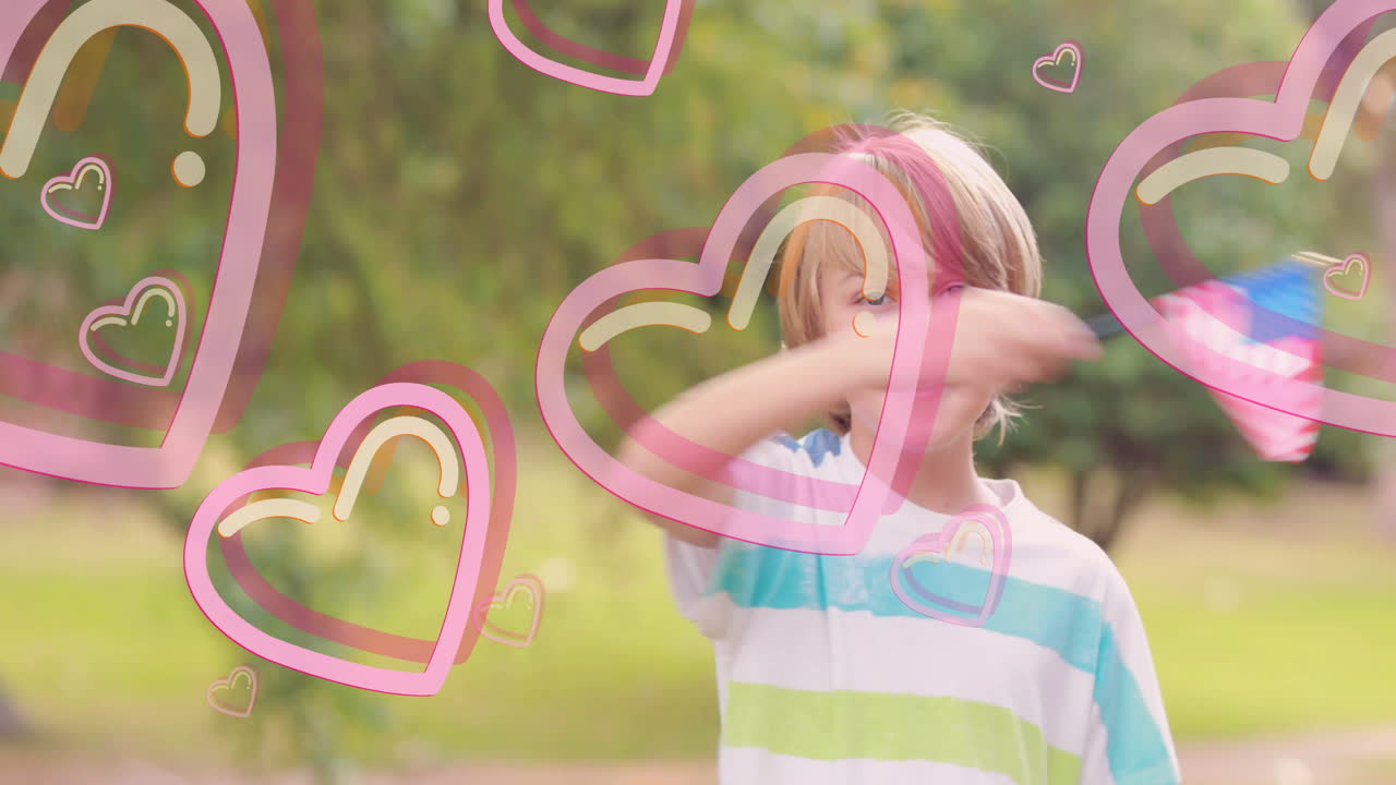 Young boy waving American flag with heart animations over green background