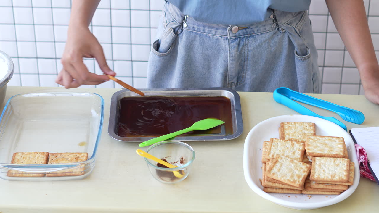 한 여자 의 손 은 커피 에 비스 을 담그고 유리 그 에 넣어 티라미수 케이크 를 만든다