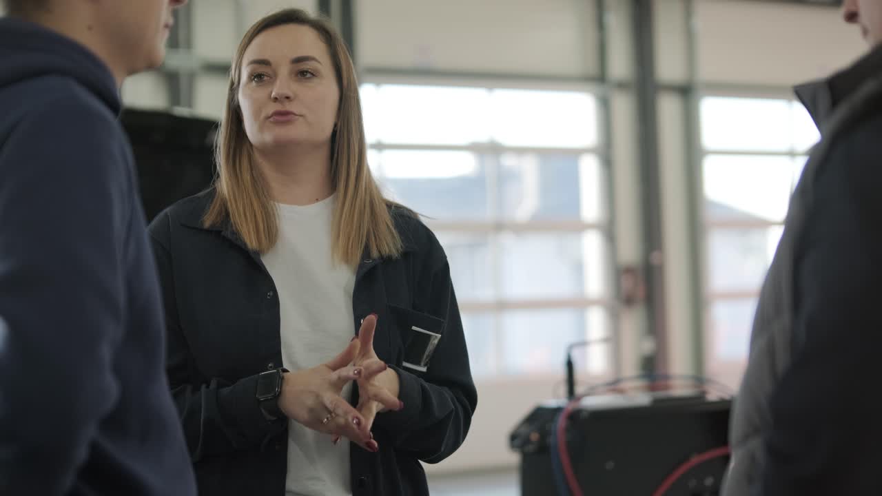 gerente femenina discutiendo la reparación de vehículos con el mecánico en el taller de reparación de automóviles