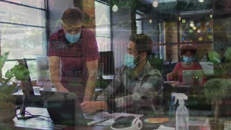 Animation-of-trading-board-moving-over-caucasian-male-coworkers-in-masks-discussing-over-laptop