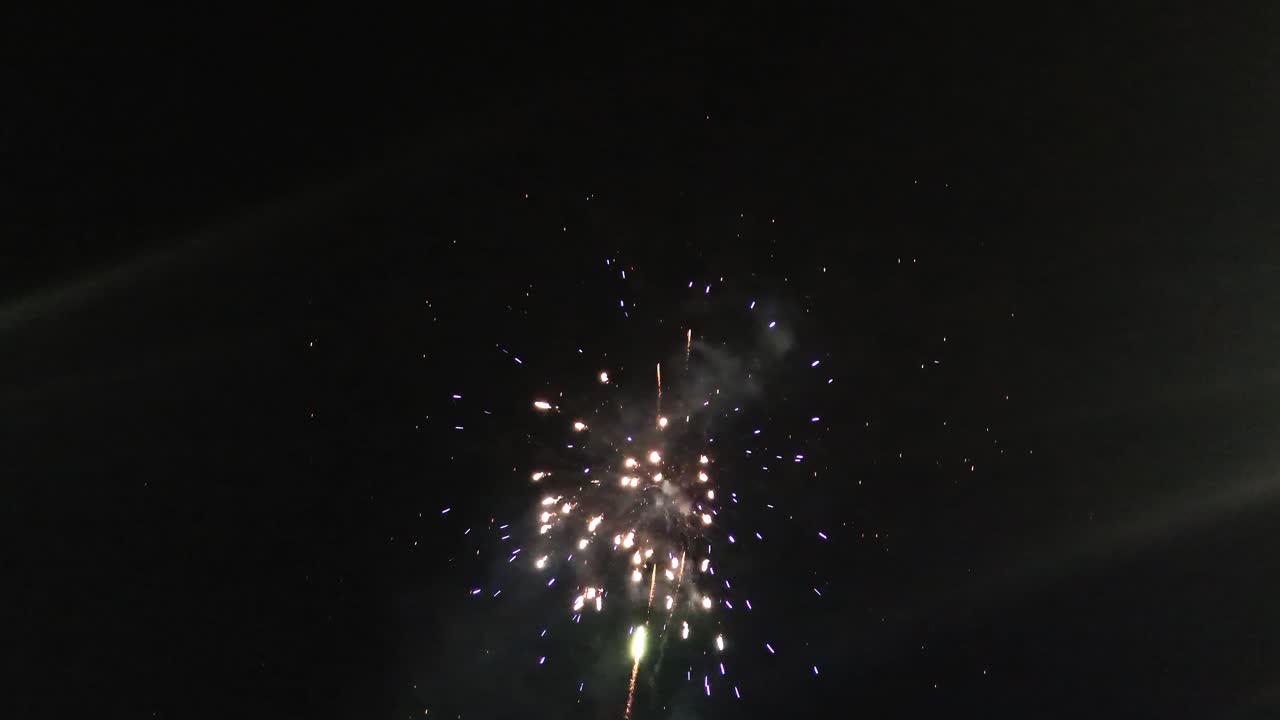 Colorful Green, Red, Purple Fireworks Blowing Up in Night Sky During Celebration for Christmas Parade. Happy New Year's Eve Party Event. Glowing Lights Pyrotechnics