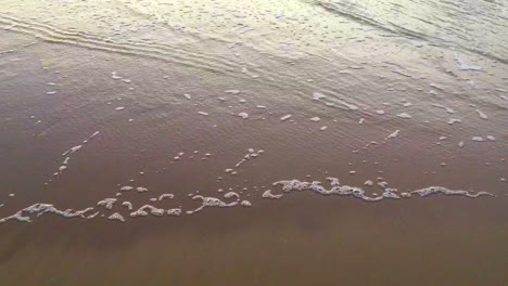 Welle,-Die-Bei-Sonnenuntergang-Auf-Nassem-Sand-Den-Strand-Hochläuft