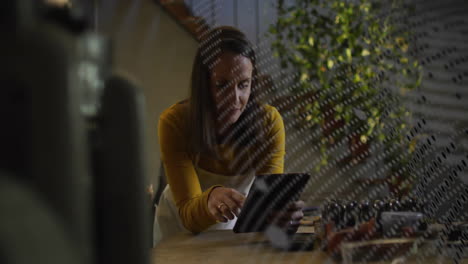 animation of globe with data processing over biracial businesswoman using tablet in office