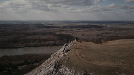 Aerial-shot-of-Rocky-cliff-vista-point-in-Hainburg,-Austria-with-Danube-river-in-background