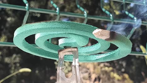 a green smoking mosquito coil