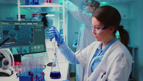 chemist putting liquid in test tube with micropipette