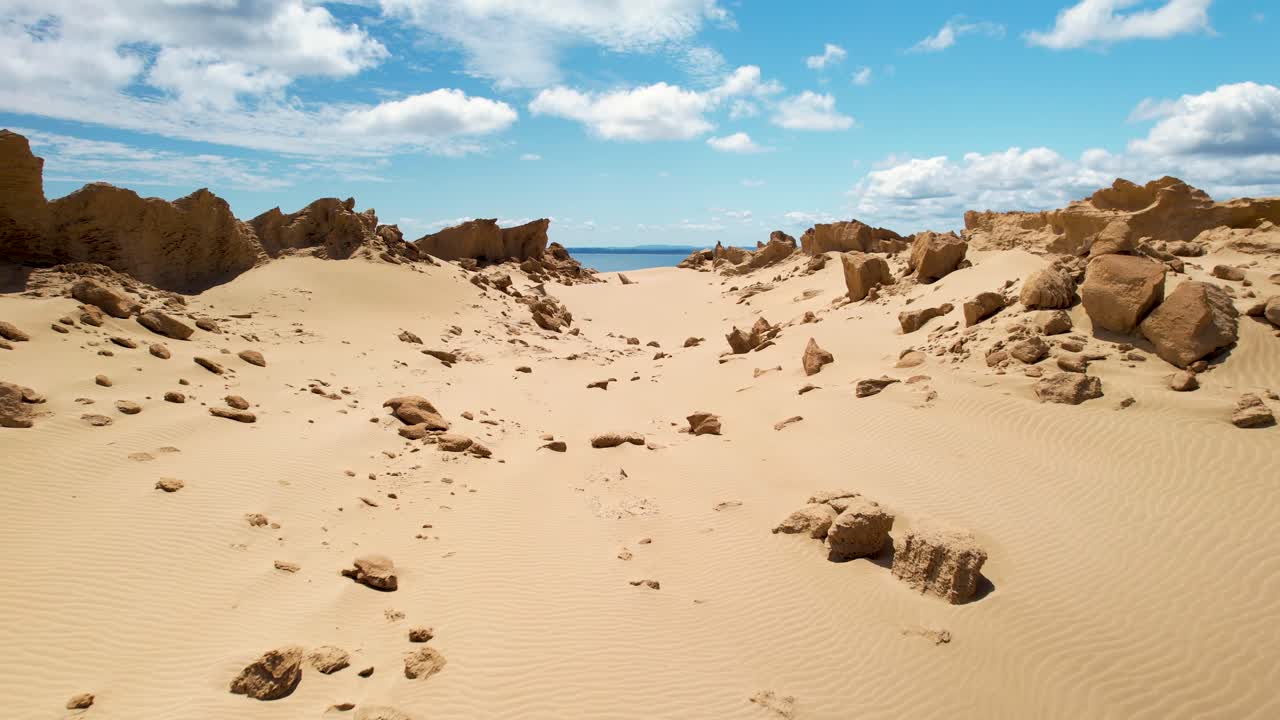 drone cerca del desierto arenoso y formación rocosa, ubicación remota en la costa de nueva zelanda